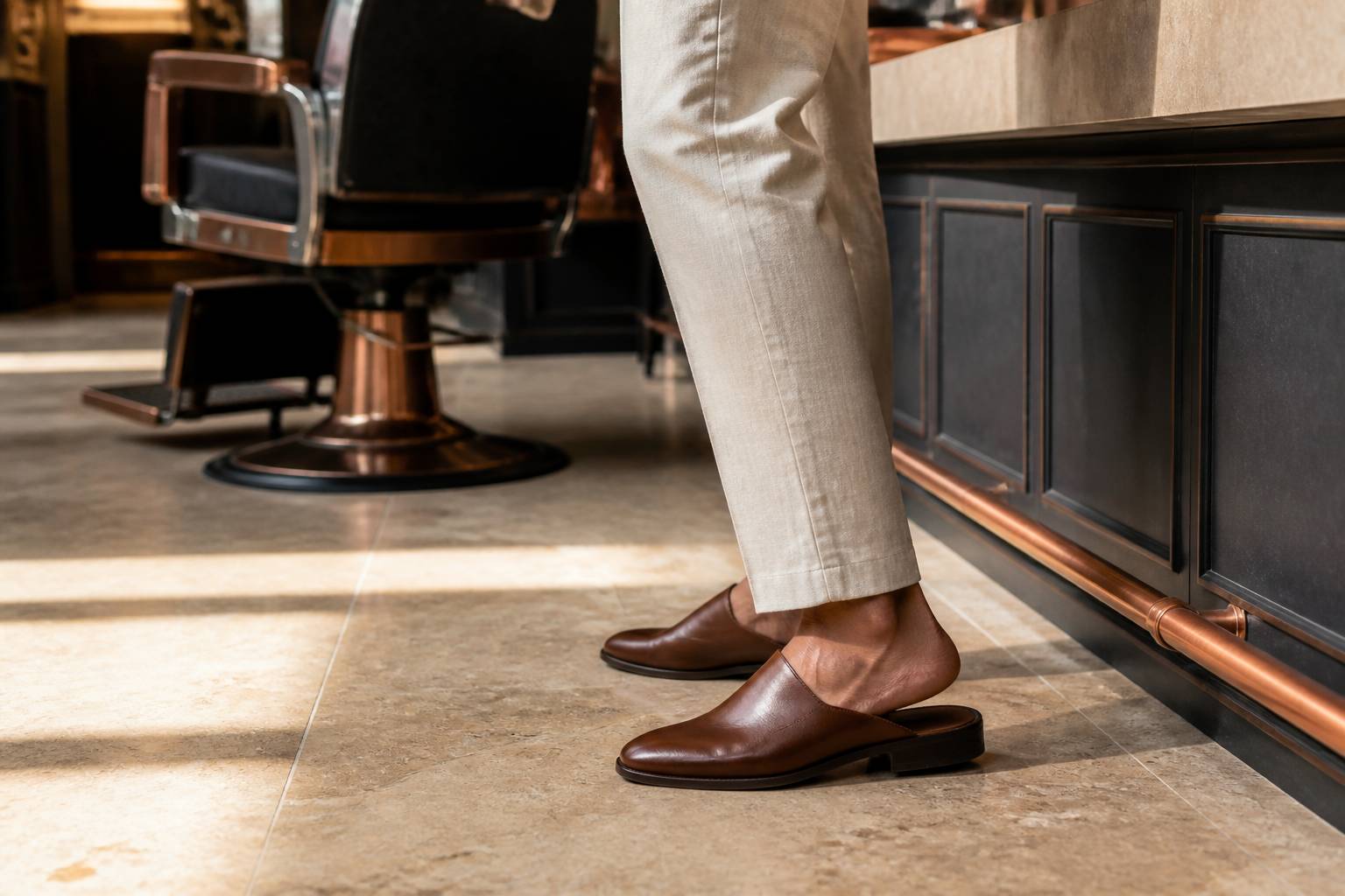 Mule en cuir brun portée avec un pantalon en lin