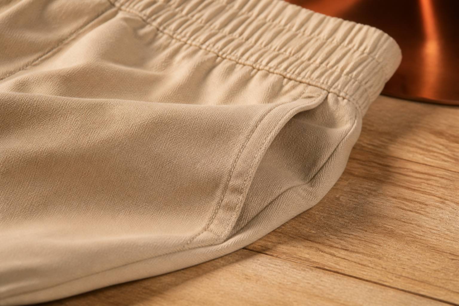 Gros plan sur la ceinture élastique et la couture d'un short en coton beige