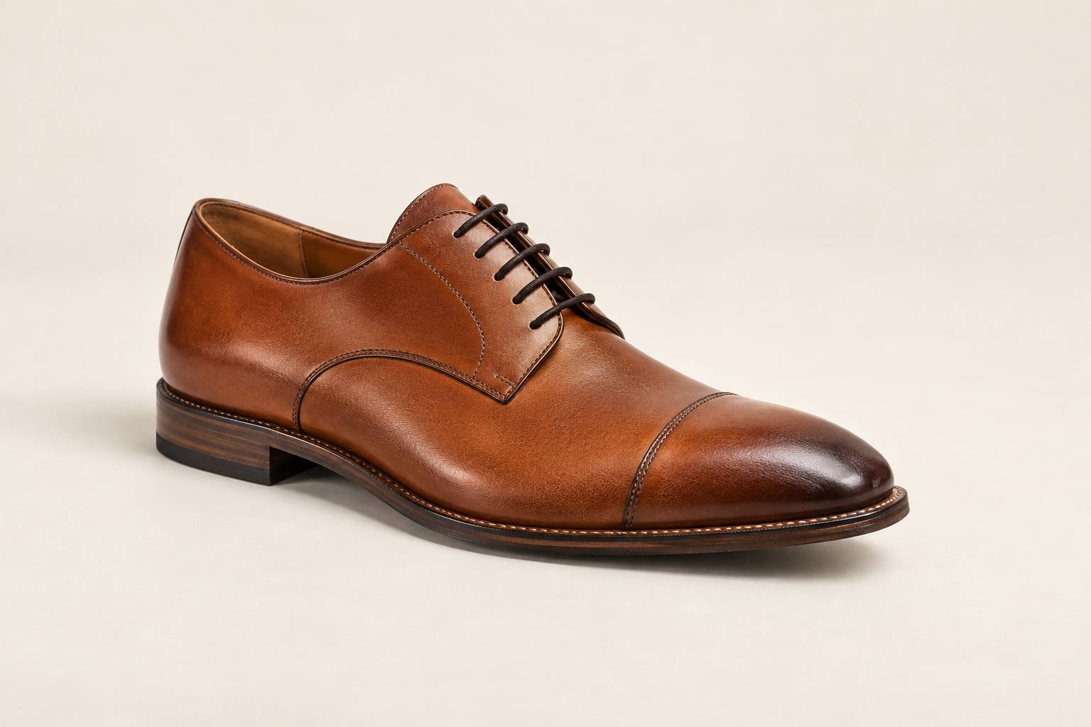 Chaussure en cuir avec couture apparente et semelle cousue sur fond crème